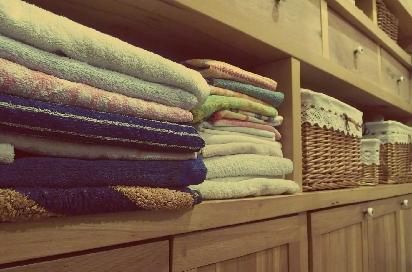 Toallas de colores apiladas en una estantería de madera
