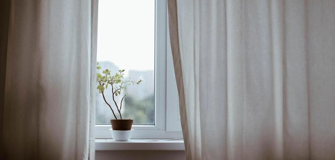 Cortinas a medida junto a una ventana